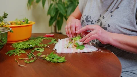 Woman Preparing Easter Egg With Herbs Wrapped In Cloth On Wooden Table 库存影片 326462795