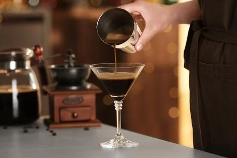 Woman preparing Espresso Martini on bar counter, closeup. Alcohol cocktail Stock Photos