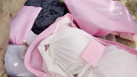 Woman preparing her luggage using pink packing cubes to organize clothes an.. Stock Footage 334552045