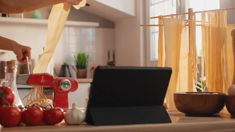 A woman preparing pasta using digital tablet Stock Footage 235546350