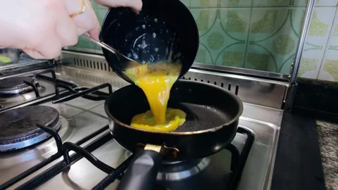 Woman preparing scrambled eggs for breakfast at home Видео 335592292