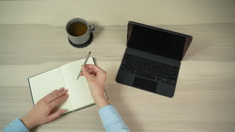 Woman preparing to write in notebook at minimalist workspace, top view Video stock 329010419