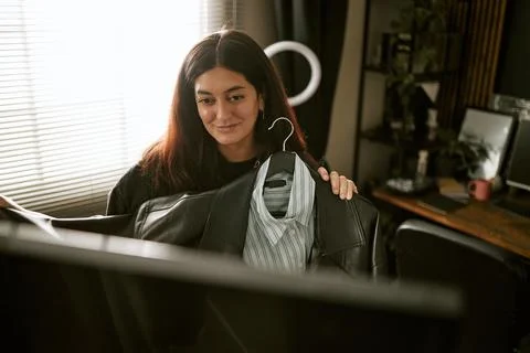 Woman Presenting Clothes on Hanger via Computer Monitor Stock Photos