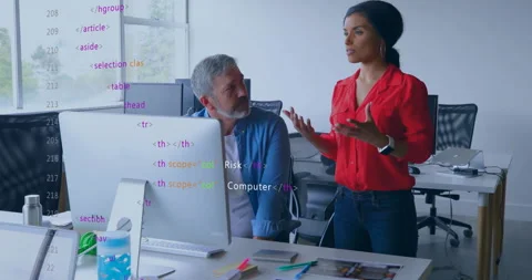 Woman presenting code review to colleague in open-plan office, showing animated Stock Footage 307439705