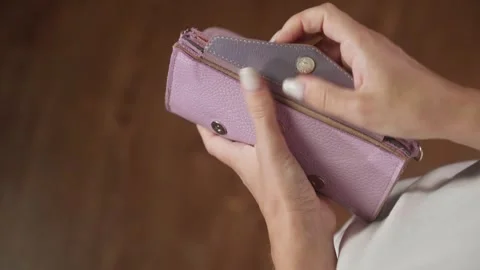 Woman presenting features of a small purple leather wallet Vidéo 284845435