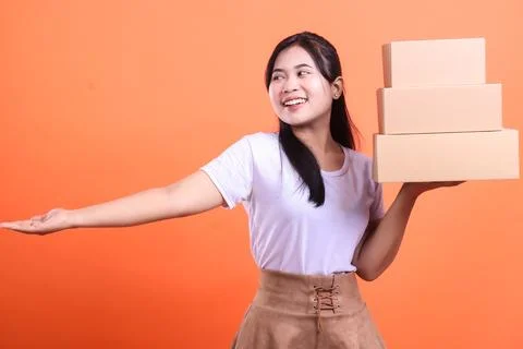 Woman presenting a stack of packages Stock Photos