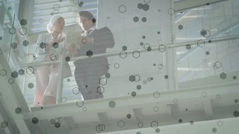 Woman presenting tablet, man pointing, both reviewing business data under Stock Footage 334694336