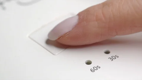 Woman presses the button to set the timer on uv led lamp. Switching the light Stock Footage 122129871