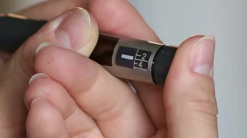 Woman presses the insulin pen and injects insulin. Stock Footage