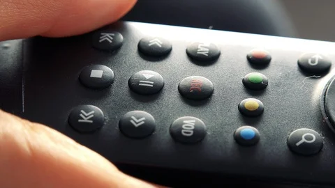 A woman presses a pause/play button on a remote control - closeup Stock-Footage 85813600
