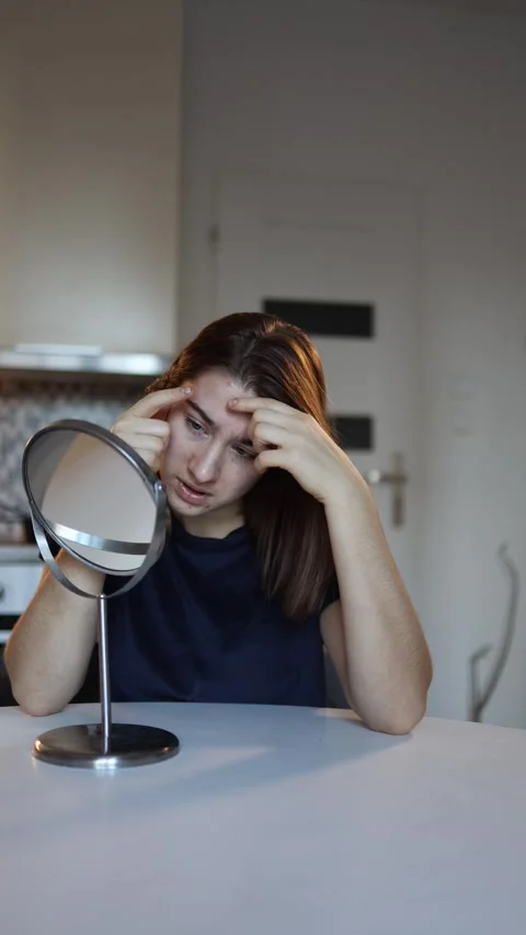 Woman presses pimples while looking in mirror Stock Footage 327217148