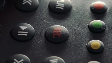 A woman presses a record button on a remote control - closeup 스톡 동영상 85815173