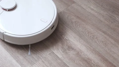 A woman presses the start button of a robot vacuum cleaner Stock Footage 166036026