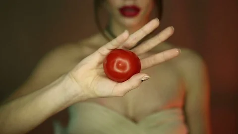 Woman presses tomatoes in her hands Stock Footage