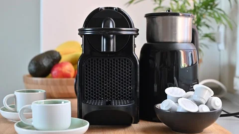 Woman pressing a button on a coffee maker and making espresso. Stock Footage 130015375