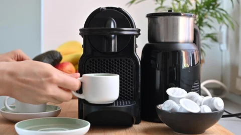 Woman pressing a button on a coffee maker and making espresso. Conceptual Stock Footage 130015624