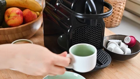Woman pressing a button on a coffee maker and making espresso. Stock Footage 130015841