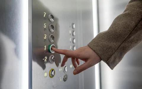 Woman pressing button inside elevator. Foto stock