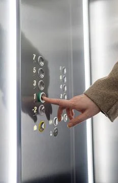 Woman pressing button inside elevator. Foto stock