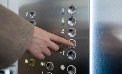 Woman pressing button inside elevator. Foto stock