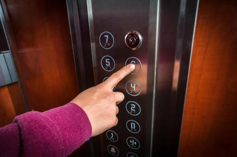 Woman pressing the button in the modern elevator interior Foto stock
