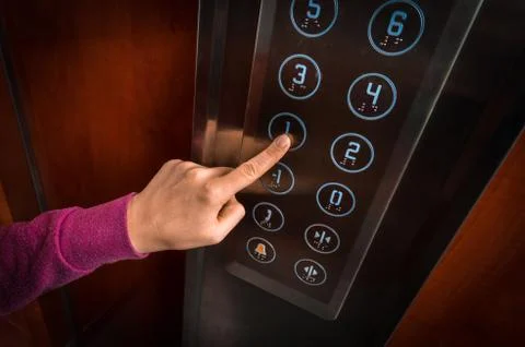 Woman pressing the button in the modern elevator interior Foto stock