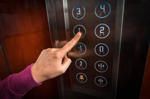 Woman pressing the button in the modern elevator interior Foto stock