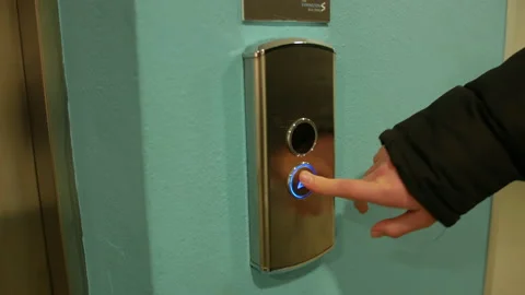 A woman pressing an elevator call button Stock Footage 234312372