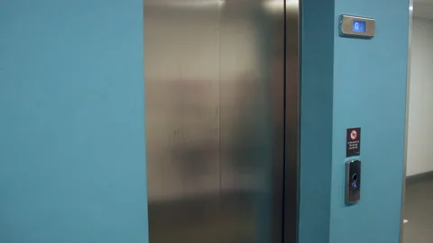 A woman pressing an elevator call button and doors opening Stock Footage 234313303