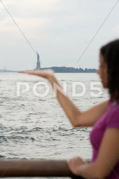 Woman pretending to hold statue of liberty Stock Photos