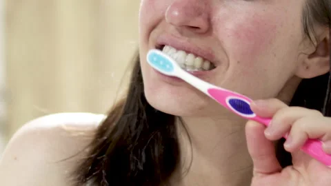 Woman with problematic skin is brushing her teeth 動画素材 189935053