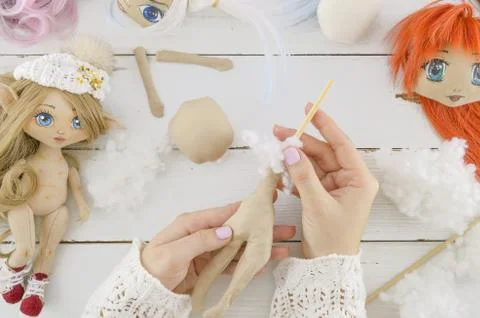 Woman in the process of creating handmade doll, top view, seamstress workplace Stock Photos