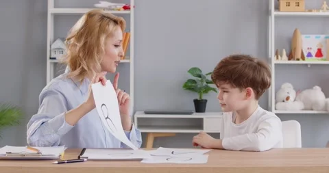 Woman professional language pathologist doing articulation exercises with little Stock Footage 295626854
