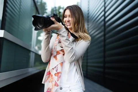 Woman is a professional photographer with dslr camera, outdoor and sunlight Stock Photos