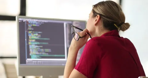 Woman programmer inspects code looking for errors on screen Stock Footage 241487077