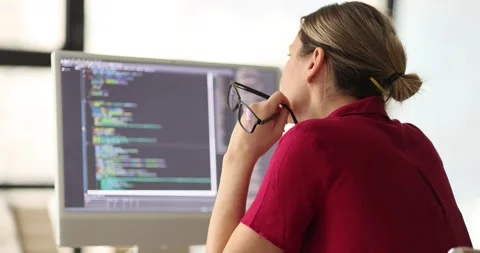 Woman programmer inspects code looking for errors on screen Stock Footage 275586658