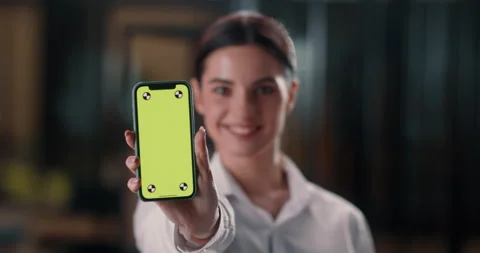Woman programmer looking at his creation and showing screen of smartphone on Stock Footage 224300974