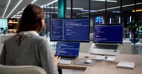 Woman Programmer Types Code Diligently On Desktop, Developing New Software. Stock Photos