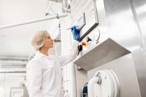 Woman programming computer at ice cream factory Foto stock
