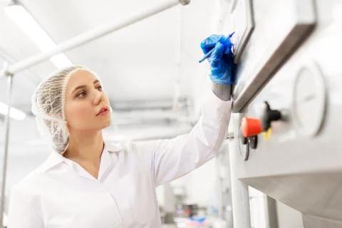 Woman programming computer at ice cream factory Stock Photos