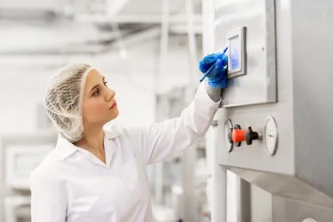 Woman programming computer at ice cream factory Stock-Fotos
