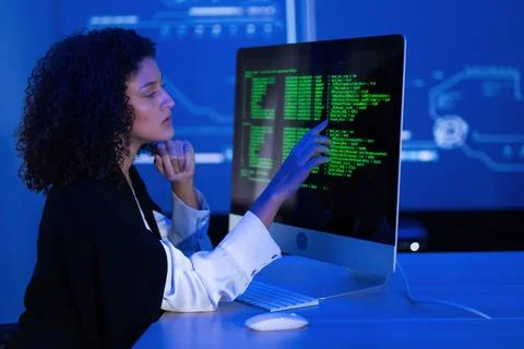 Woman programming on a computer screen with coding in a high-tech environme.. Stock Photos