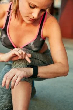 Woman programming her smartwatch before going jogging to track performance Stock Photos