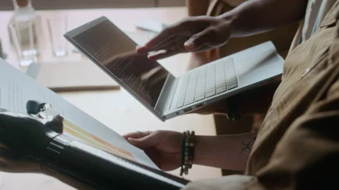 Woman with Prosthetic Arm Discussing Code and Document with Colleagues in Office Stock Footage 306212123