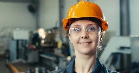 Woman in a protective helmet smiling while in an industrial plant Stock Footage 201604242