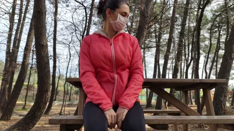 Woman with protective mask on face using hand sanitizer Stock Footage 130582701