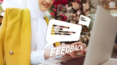 Woman providing feedback while using a laptop in a vibrant cafe environment Foto stock