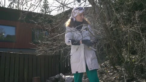 A woman pruning tree branches with pruning shear Stock Footage 299953947