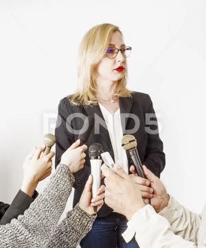 Woman Public Speaker and Hands of Reporters With TV Microphones and Voice Rec Stock Photos