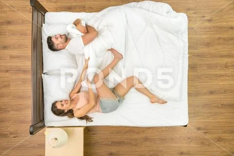The woman pull a blanket on the bed. View from above Stock Photos